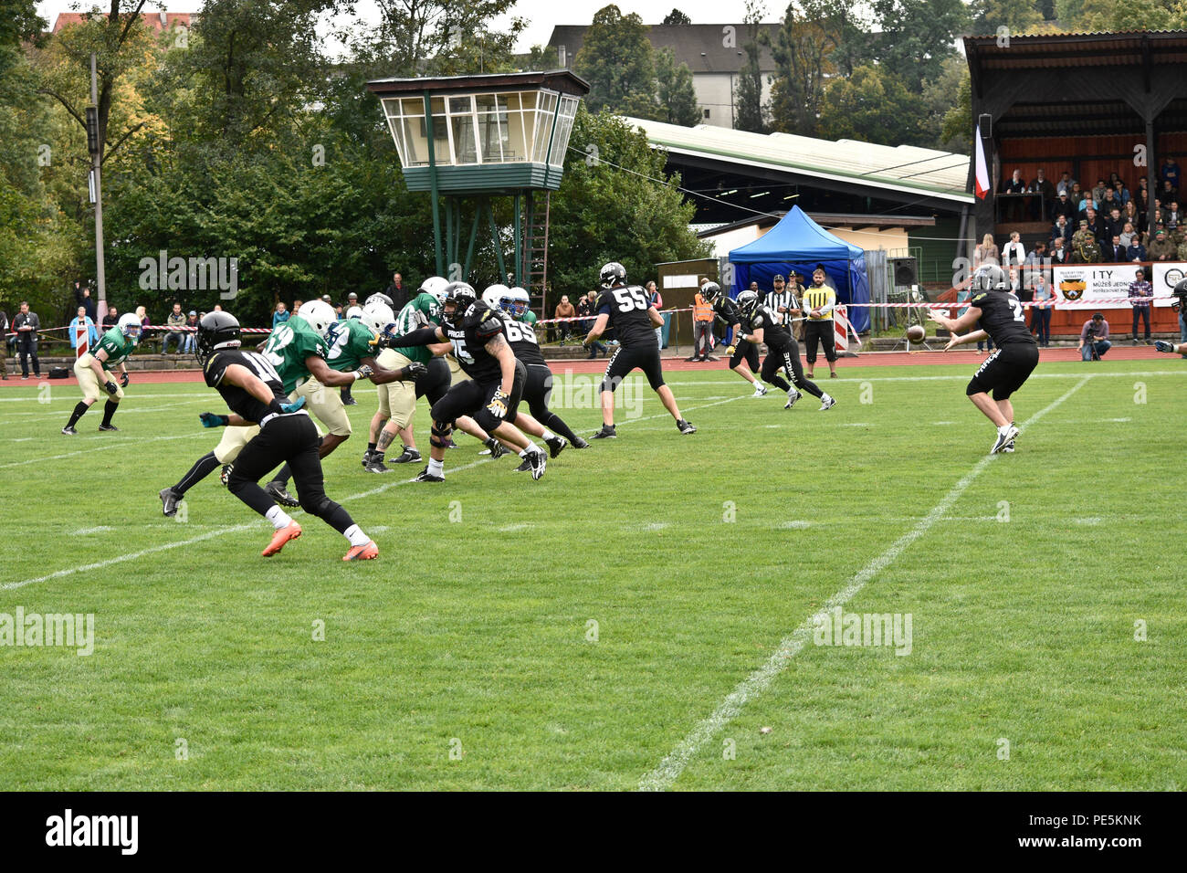 Offensive players from the Prague Black Panthers run a play against defensive players from the 2nd Cavalry Regiment's football team during their game in Cesky Krumlov, Czech Republic, Sept. 26, 2015. The team participated in an American football game with the local Czech Republic semi-professional football team as the unit helped to commemorate the 70th anniversary of Cesky Krumlov's liberation during World War II while also demonstrating the U.S. commitment to their NATO and Czech allies. (U.S. Army photo by Sgt. William A. Tanner/released) Stock Photo