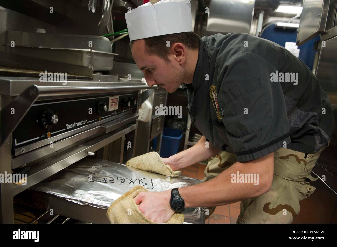 150923-N-FI568-059 GULF OF ADEN (Sept. 23, 2015) – Culinary Specialist 2nd Class Justin Graham, from Cincinnati, Ohio, prepares hamburgers in the wardroom galley aboard the Arleigh Burke-class guided missile destroyer USS Winston S. Churchill (DDG 81). USS Winston S. Churchill is deployed in the U.S. 5th Fleet area of operations supporting Operation Inherent Resolve, strike operations and theater security cooperation efforts in the region. (U.S. Navy photo by Mass Communication Specialist 3rd Class Taylor L. Jackson/Released) Stock Photo