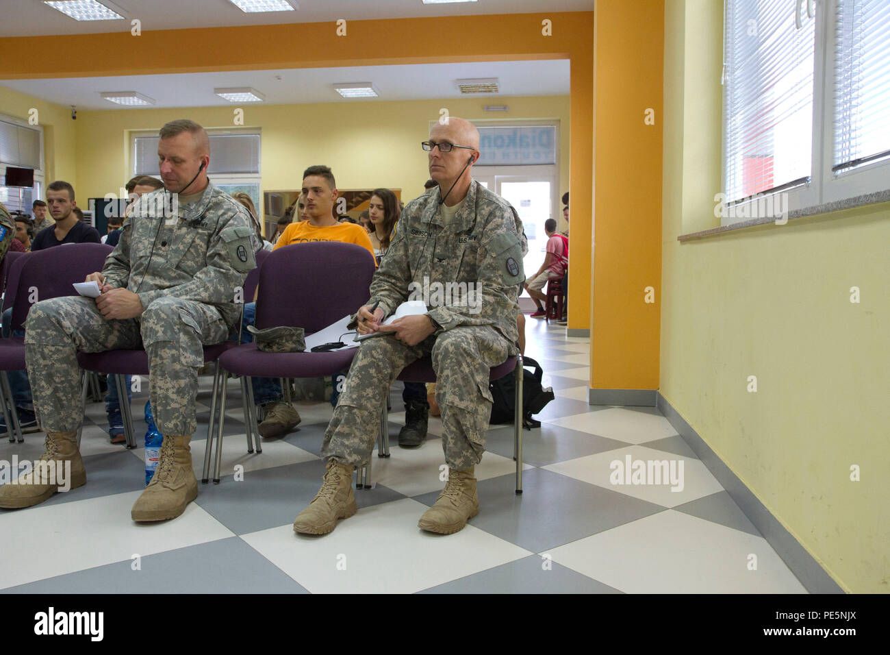 U.S. Army Lt. Col. William Gray (left), commander for 1st Combined Arms Battalion, 252nd Armor Regiment, and Col. Vernon Simpson, commander of the 30th Armored Brigade Combat Team and Multinational Battle Group-East, listen during a Violence Free Future workshop discussion to promote tolerance in Kosovo, Sept. 19, 2015, in Mitrovica, Kosovo. Simpson and Gray are both North Carolina National Guard leaders for units deployed to Kosovo as part of NATO’s Kosovo Force peace support mission. The workshop, along with a Play2Educate youth event, was sponsored by the U.S. Embassy and led by Rotary Club Stock Photo
