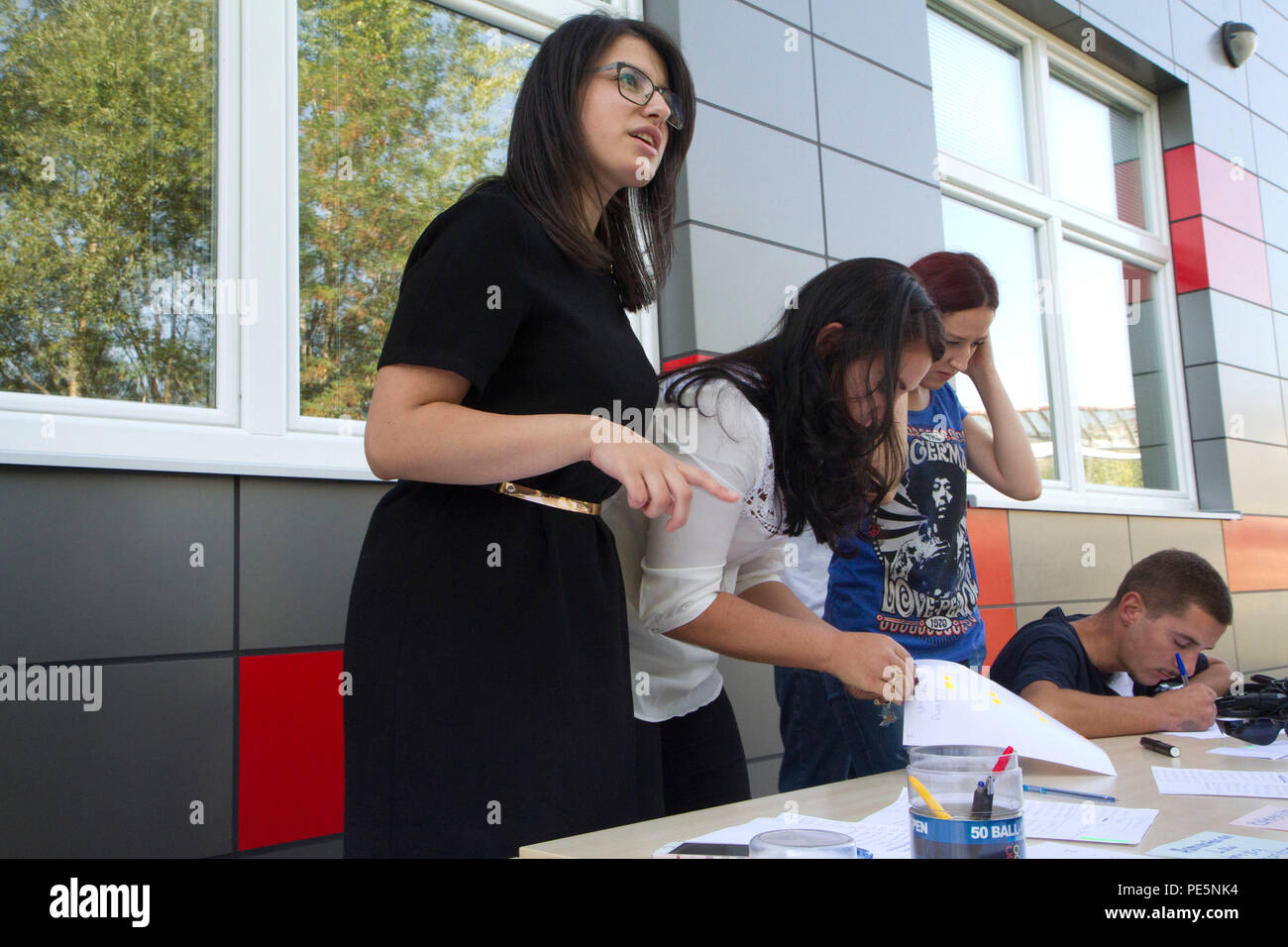 Egzona Bokshki (left), president of Rotaract Club Illyrian and a recent University of Pristina graduate, greets attendees as they sign in for a Violence Free Future workshop and Play2Educate youth event Sept. 19, 2015, in Mitrovica, Kosovo. These events, sponsored by the U.S. Embassy and led by Rotary Club Pristina, promote pro-social behaviors for young men and women in Kosovo regardless of gender or ethnic background, and aim to keep students positively engaged in school and their community. Hungarian and U.S. soldiers assigned to Multinational Battle Group-East attended the event as volunte Stock Photo