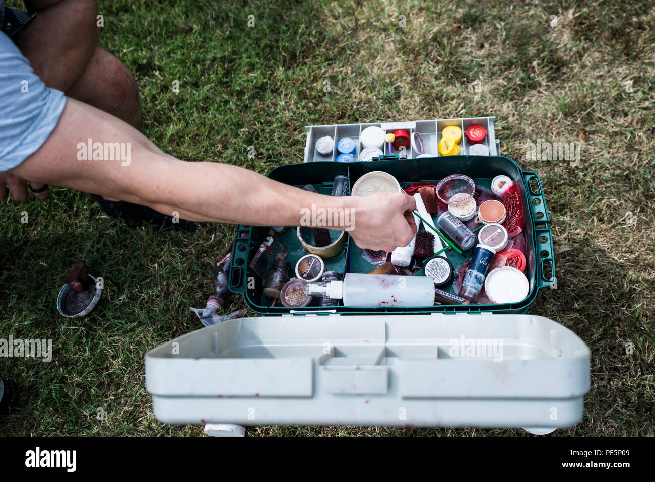 A U.S. Air Force Airman reaches for moulage equipment prior to a mass