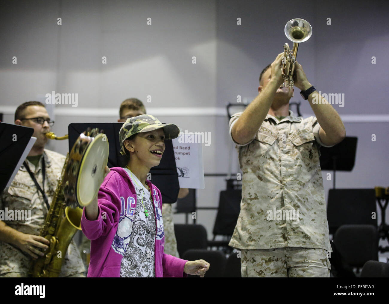 Amber N. Carter, a resident of Hubert, N.C., plays music alongside the 2nd Marine Division Band during her visit to the band’s command post at Camp Lejeune, N.C., Sept. 29, 2015. Amber always dreamed of joining the Marine Corps, but could not due to William’s syndrome. Staff Sgt. Isaiah Riley, a mess chief with 10th Marine Regiment, brought her and her family aboard the base to watch the band play. (U.S. Marine Corps photo by Cpl. Paul S. Martinez/Released) Stock Photo