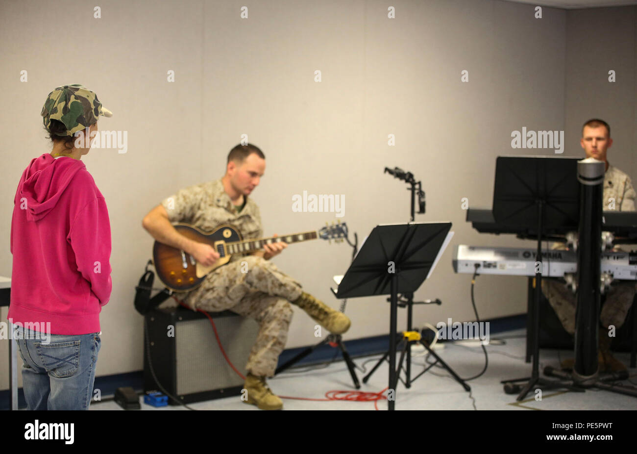 Amber N. Carter, right, a resident of Hubert, N.C., watches members of the 2nd Marine Division Band conduct rehearsal at the band’s command post at Camp Lejeune, N.C., Sept. 29, 2015. Amber always dreamed of joining the Marine Corps, but could not due to William’s syndrome. Staff Sgt. Isaiah Riley, a Marine with 10th Marine Regiment, brought her and her family aboard the base to watch the band play. (U.S. Marine Corps photo by Cpl. Paul S. Martinez/Released) Stock Photo