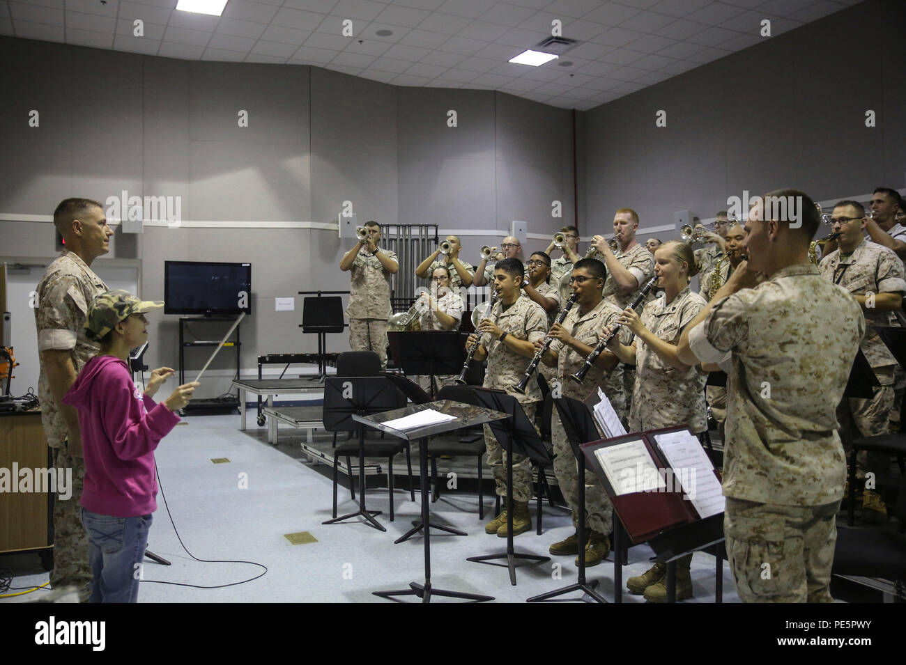 Amber N. Carter, a resident of Hubert, N.C., conducts “The Marines’ Hymn” for the 2nd Marine Division Band during her visit to their rehearsal at the band’s command post at Camp Lejeune, N.C., Sept. 29, 2015. Amber always dreamed of joining the Marine Corps, but could not due to William’s syndrome. Staff Sgt. Isaiah Riley, a mess chief with 10th Marine Regiment, brought her and her family aboard the base to watch the band play. (U.S. Marine Corps photo by Cpl. Paul S. Martinez/Released) Stock Photo