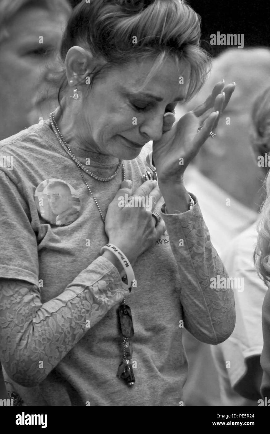 Gold Star mother Christine Koch holds her hand over her heart during the National Anthem at the dedication ceremony for the Gold Star Family monument at the Vietnam Veterans Museum on Holmdel, N.J., Sept. 27, 2015. (U.S. Air National Guard photo by Tech. Sgt. Matt Hecht/Released) Stock Photo