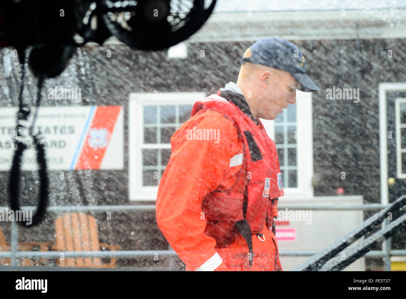 Petty Officer 3rd Class Sam Edes braves the weather to secure a 29-foot ...
