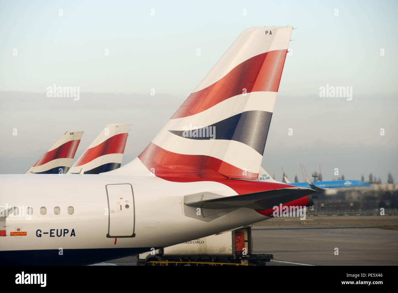 Row of tail fins of British Airways Airbus jets parked outside Terminal 5 at London Heathrow Airport Stock Photo