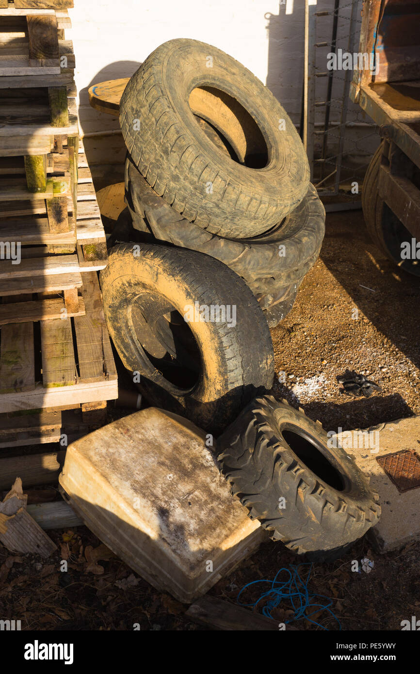 Tractor tyres and various previously used tyres lying in a pile outdoors on a wine estate Stock Photo