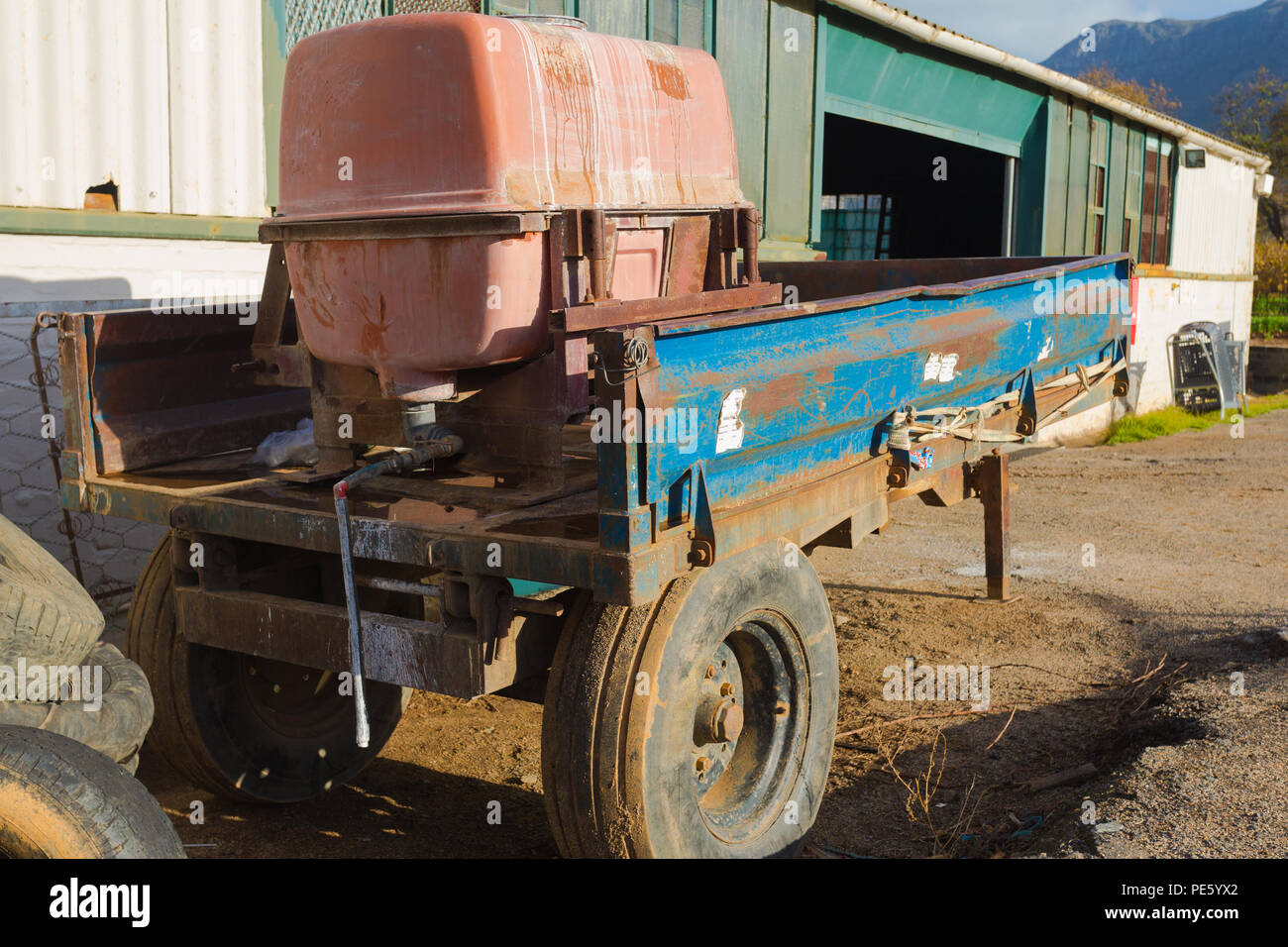 parked trailer loaded with sprayer used in the vineyards or viticulture industry outdoors next to a shed on a wine estate in Cape Town Stock Photo