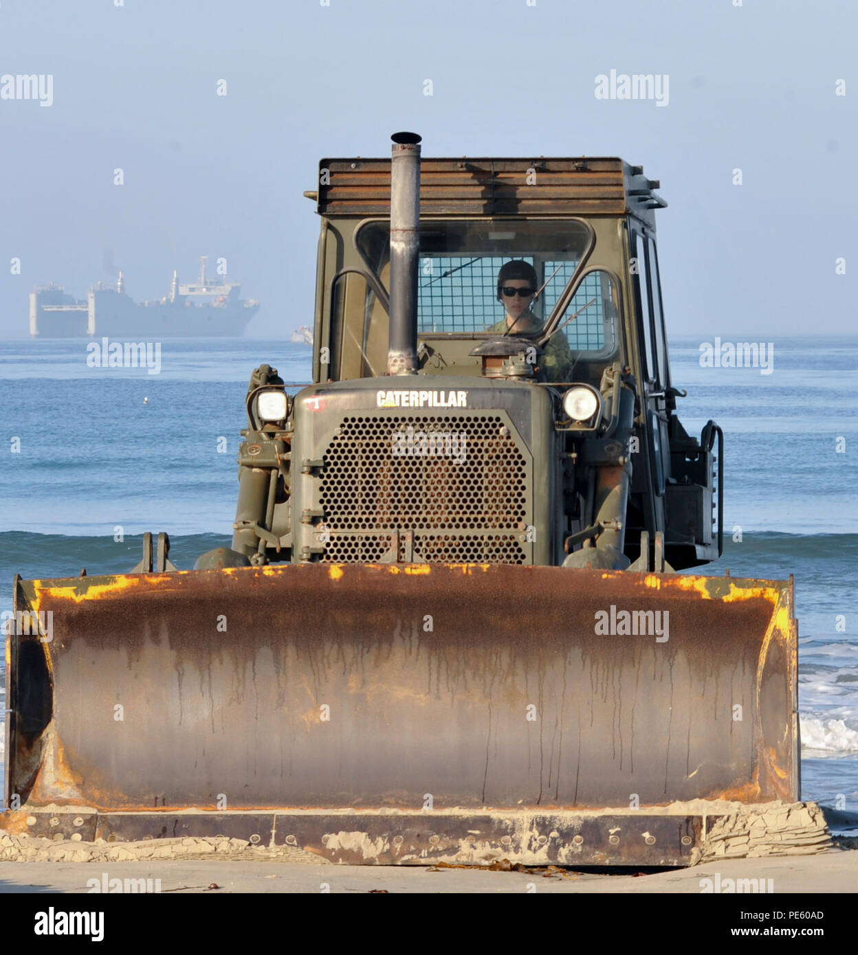 150925-N-KK081-103 SAN DIEGO (Sept. 25, 2015) – Equipment Operator Constructionman Harley Suttles, attached to Amphibious Construction Battalion (ACB) 1’s Alfa Company, drives bulldozer to build a sand ramp during Exercise Brilliant Zenith 2015 (BZ15). BZ15 is an assault follow-on echelon exercise designed to conduct ship-to-shore transportation of Navy cargo with the Improved Navy Lighterage System Floating Causeway embarked on SS Cape Mohican (T-AKR 5065) and improve interoperability with Naval Beach Group 1, ACB 2, Expeditionary Warfare Training Group, Pacific and Navy Cargo Handling Battal Stock Photo