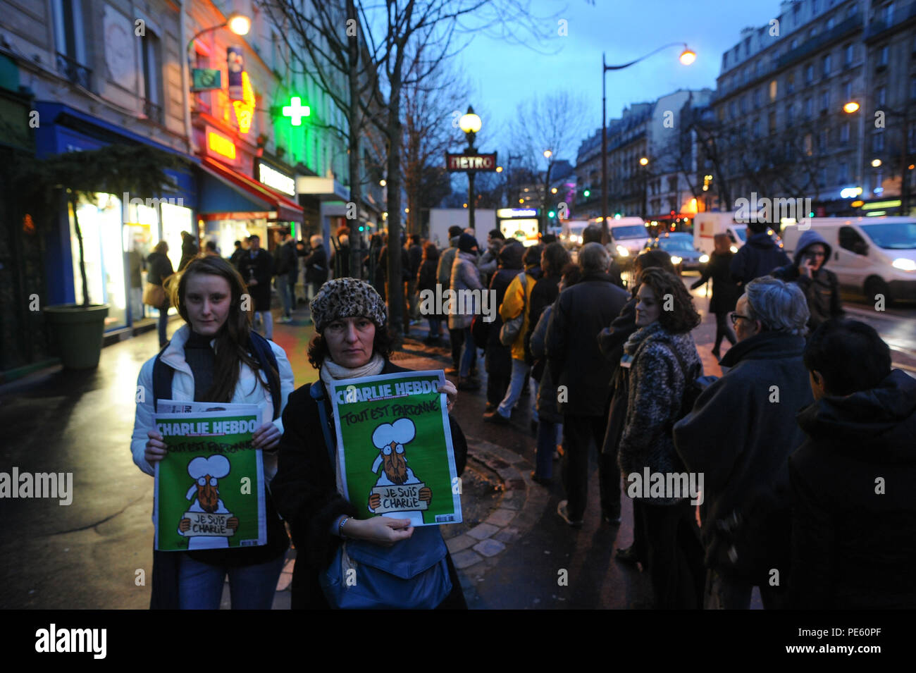 January 14, 2015 - Paris, France:  French people queue at a press kiosk as they wait to buy the latest issue of Charlie Hebdo magazine. Some 3 million copies of Charlie Hebdo - the survivors' issue, with a cartoon of prophet Muhammad on its cover - have been printed following a deadly shooting attack on its staff by Islamist gunmen. File d'attente devant un marchand de journaux pour la sortie du numero de survivants de Charlie Hebdo, une semaine apres l'attentat meurtrier contre sa redaction. La couverture est une caricature du prophete Mahomet avec une pancarte disant 'je suis Charlie'. *** F Stock Photo