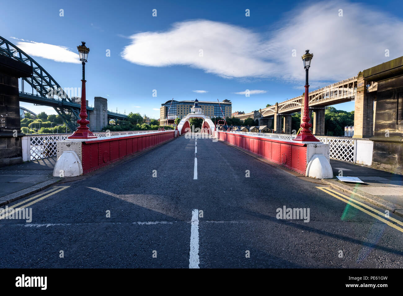 Footpath on either sides of the unique red painted swing bridge in Newcastle, UK Stock Photo