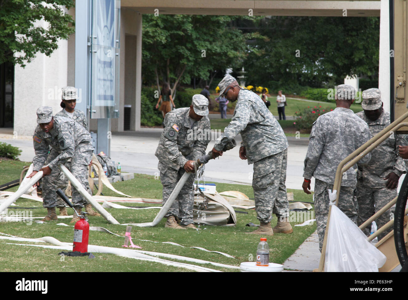 South Carolina National Guard Soldiers from the 741st Quartermaster Battalion drag hoses around the grounds of Richland Memorial Hospital that will connect to water treatment equipment, Oct. 8. The 741st Quartermaster Battalion and 218th Brigade Support Battalion worked together to purify water for the hospital since most of Columbia was under a boil-water advisory. Guardsmen have been assisting in a variety of ways throughout the state after the worst rains and flooding in recorded history. The South Carolina National Guard was on call before the storms hit and continued to provide support to Stock Photo
