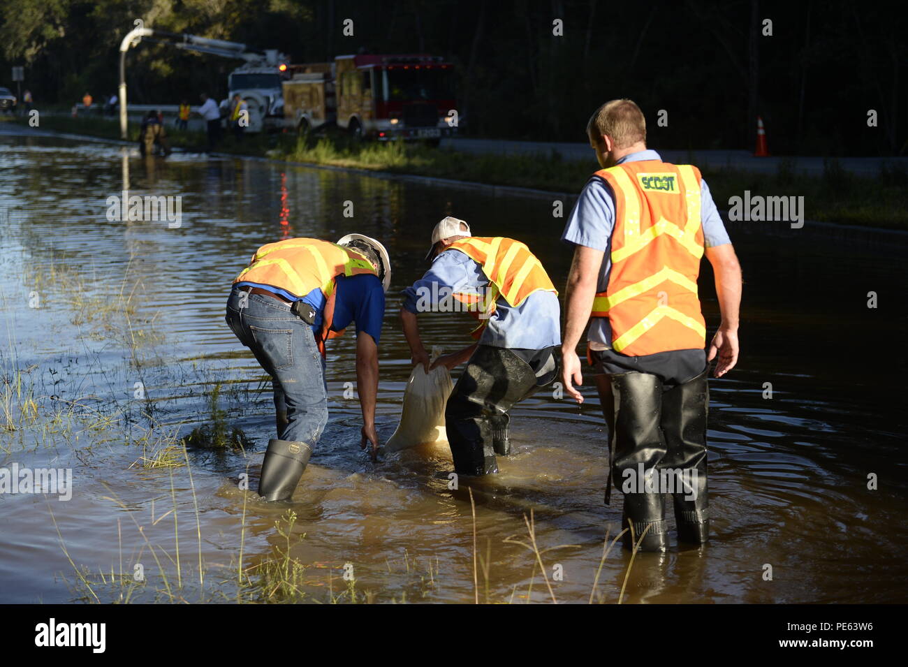 Members of the South Carolina Department of Transportation block drains on a section of Dorchester Rd. near Trolley Rd. in Summerville, S.C., Oct. 7, 2015, that was affected by recent flooding throughout South Carolina. Drains were blocked off to allow the Summerville Old Fort Fire Department to drain the water. The flooding was the result of historic levels of rain deposited in the state by Hurricane Joaquin Oct. 3, and 4. (Official U.S. Air Force photo/Capt. David J. Murphy) Stock Photo