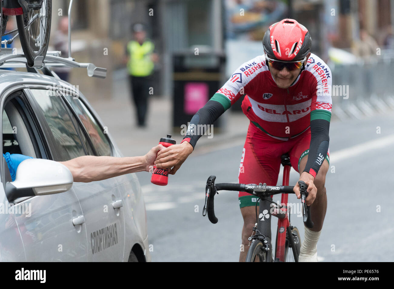 Glasgow, Scotland, UK - 12 August 2018: European Championships 2018 -  Sticky bottle?  a competitor in the men's road race first spotted by photographer at 15:35:05 appearing to take a water bottle from his support car during a hill climb in Glasgow city centre.  Subsequent photographs show that at 15:35.13 he was still holding onto the bottle (photo 2 of 3 see also images PE6578 and PE6575) Credit: Kay Roxby/Alamy Live News Stock Photo