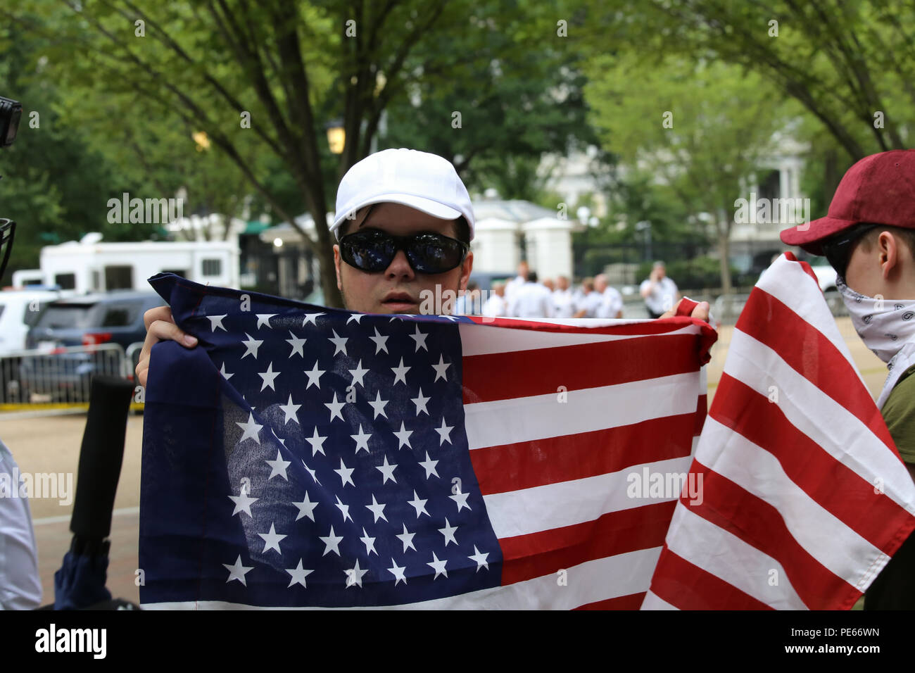 Washington, DC, USA. 12 Aug 2018. White nationalist protestors at the Unite the Right protest in front of the White House hold flags. Credit: Joseph Gruber/Alamy Live News Stock Photo