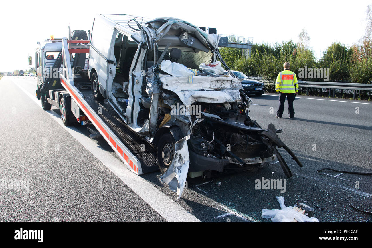 Peine, Germany. 13th Aug, 2018. After a serious accident on the A2 motorway  between Peine-Ost and Haeelerwald, a completely destroyed van is  transported away in the direction of Hanover. The two passengers