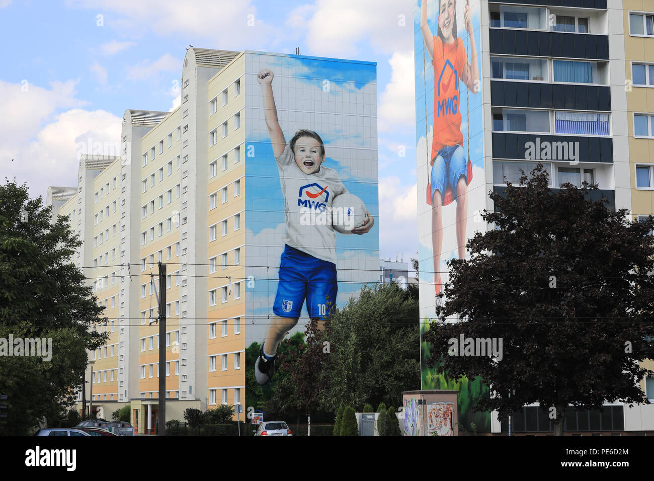 Magdeburg, Germany. 12th Aug, 2018. The largest graffito of the city of Magdeburg on the gable wall of a ten-storey house will be officially presented on 13 August 2018. On the façade of the building, Tyler can be seen in a jubilant pose with a soccer ball under his arm. He wears a white T-shirt with the MWG logo and short FCM trousers number 10 (number of FCM defender Nico Hammann). Credit: Peter Gercke/dpa-Zentralbild/ZB/dpa/Alamy Live News Stock Photo