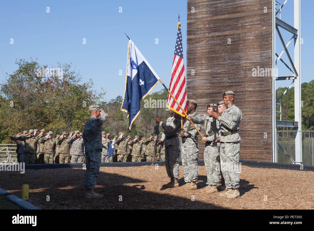 U.S. Soldiers salute the National Anthem during a Ranger Graduation that included the third female to graduate the school on Oct. 16, 2015, in Fort Benning, Ga. The United States Army Ranger School is an intense 61-day combat leadership course oriented toward small-unit tactics. (U.S. Army Photo by Spc. Jessica Hurst/ Released) Stock Photo