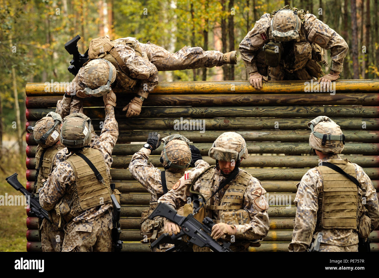 Latvian army soldiers get over a wall obstacle at the Tactical Shoot lane during the European Best Squad Competition (EBSC) held at the 7th Army Joint Multinational Training Command's Grafenwoehr Training Area, Germany, Oct. 19, 2015. The EBSC is an Army Europe competition challenging militaries from across Europe to compete and enhance teamwork with Allies and partner nations. The competition is multinational by design and involves units from 13 nations with 17 squads competing for the right to be Europe's Best Squad. (U.S. Army photo by Visual Information Specialist Markus Rauchenberger/rele Stock Photo