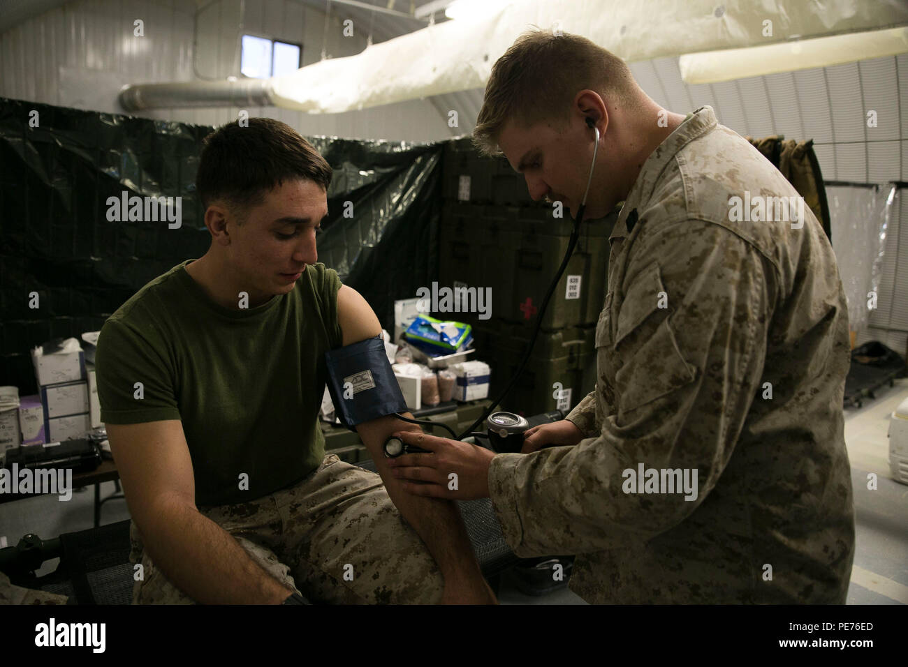 Petty Officer Third Class Alexander Iwan, a corpsman with the 8th Regimental Aid Station, takes a patient’s blood pressure during Integrated Training Exercise 1-16 aboard Marine Air Ground Combat Center Twentynine Palms, Calif., Oct. 24, 2015. The 8th Regimental Aid Station provides medical care to Marines as needed during ITX while also demonstrating their abilities to operate in a field environment. (U.S. Marine Corps photo by Sgt. Tia Nagle/Released) Stock Photo