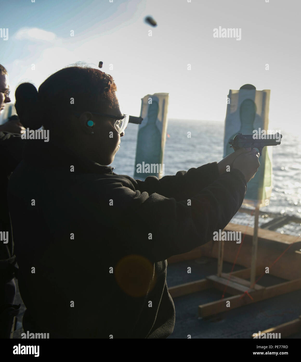 151026-N-GR718-230 PACIFIC OCEAN (Oct. 26, 2015) Boatswain’s Mate Seaman Elana Hunter fires a Beretta 9mm pistol during a live fire exercise on the flight deck of amphibious transport dock ship USS New Orleans (LPD 18). Boxer Amphibious Ready Group (ARG), composed of New Orleans, amphibious assault ship USS Boxer (LHD 4), dock landing ship USS Harpers Ferry (LSD 49), and the 13th Marine Expeditionary Unit, is conducting a Composite Training Unit Exercise (COMPTUEX) to test their ability to effectively respond to scenario driven events and perform as an integrated unit in preparation for deploy Stock Photo