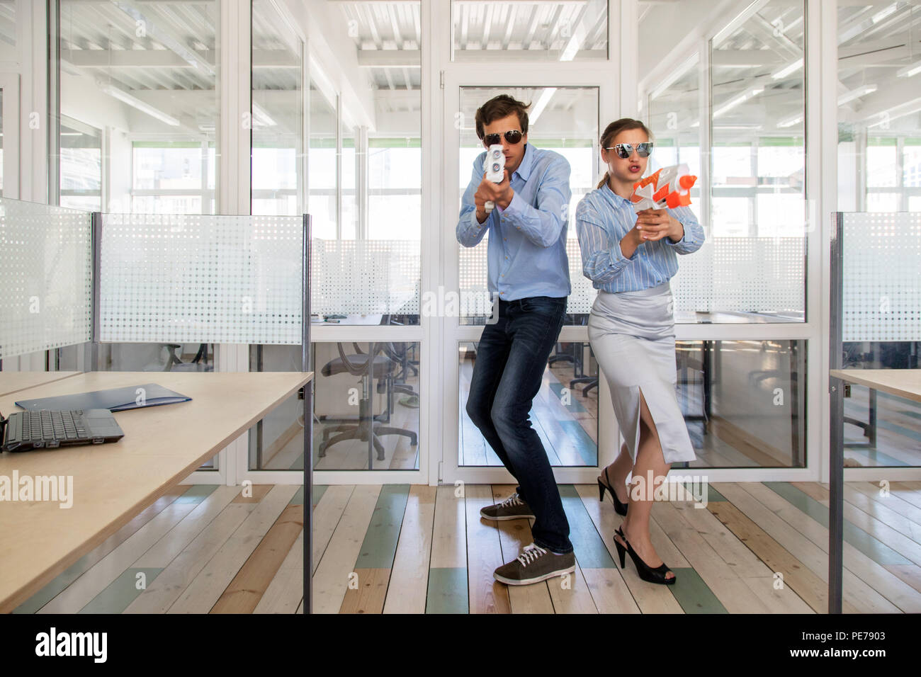 Colleagues with toy guns in office Stock Photo