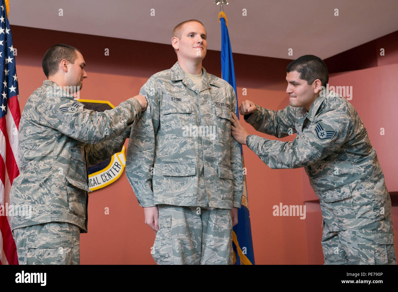 Senior Airman Benjamin Kovacevic, 60th Medical Group, left, and Staff Sgt. Roberto Davila, 60th Medical Group, right, tack senior airman stripes onto Spencer Stone, 60th Medical Operations Squadron medical technician, during a promotion ceremony at Travis Air Force Base, Calif., Oct. 30, 2015. Following his promotion to senior airman, Stone was promoted to the rank of staff sergeant by order of Air Force Chief of Staff Gen. Mark A. Welsh III. According to Air Force Instruction 36-502, the chief of staff of the Air Force has the authority to promote any enlisted member to the next higher grade. Stock Photo