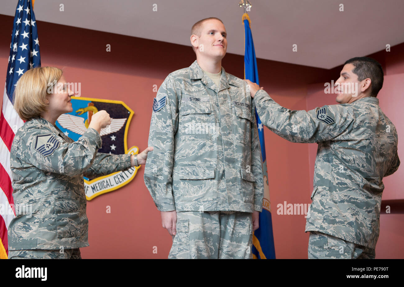 Master Sgt. Tanya Hubbard, 60th Medical Group, left, and Staff Sgt. Roberto Davila, 60th Medical Group, right, tack staff sergeant stripes on to Spencer Stone, 60th Medical Operations Squadron medical technician, during a promotion ceremony at Travis Air Force Base, Calif., Oct. 30, 2015. Following his promotion to senior airman minutes earlier, Stone was promoted to the rank of staff sergeant by order of Air Force Chief of Staff Gen. Mark A. Welsh III. According to Air Force Instruction 36-502, the chief of staff of the Air Force has the authority to promote any enlisted member to the next hi Stock Photo