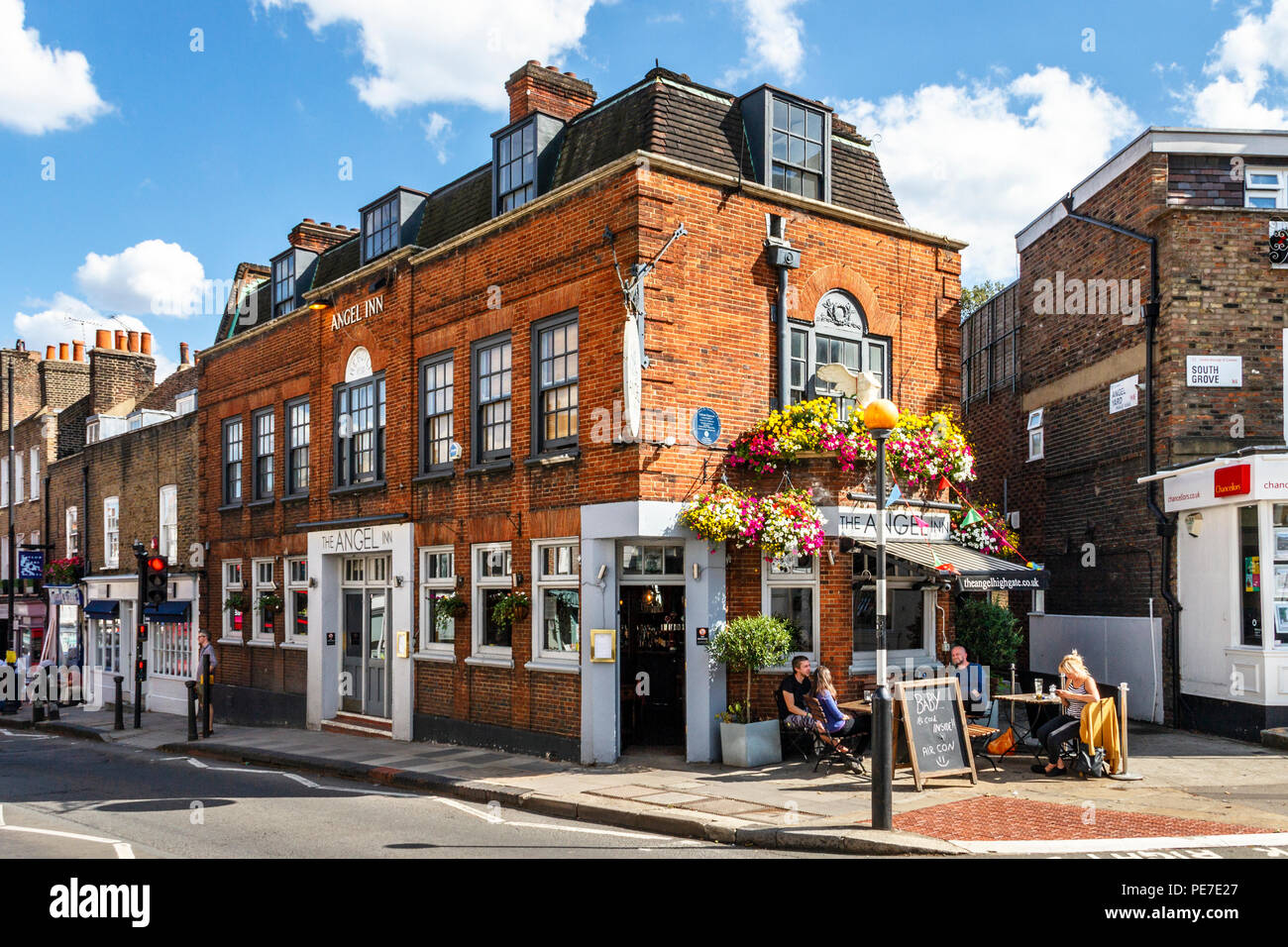 Customers drinking outside the historic Angel Inn in Highgate Village, London, UK during a heatwave Stock Photo