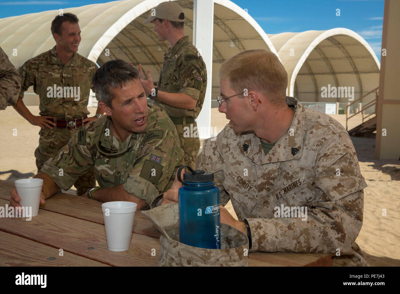 Sgt. Timothy Cordy, combat engineer, 1st Combat Engineer Battalion, and British Army Warrant Officer Class 2 James O’Neil, squadron sergeant major, 42 Commando, 3 Commando Brigade, discuss the differences between their respective countries’ services during a barbeque lunch at the conclusion of Black Alligator 15 aboard Camp Wilson, Oct. 8, 2015. (Official Marine Corps photo by Lance Cpl. Levi Schultz/Released) Stock Photo