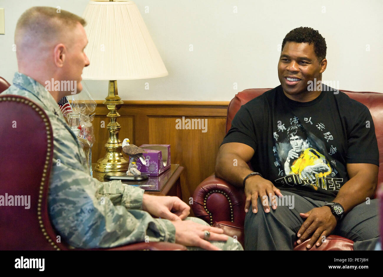 Former NFL running back and 1982 Heisman Trophy winner Herschel Walker, right, chats with Col. Michael Grismer, 436th Airlift Wing commander, left, Oct. 13, 2015, on Dover Air Force Base, Del. Walker came to meet and talk with members of Team Dover during a three-day visit to the base that included him speaking at the base theater during Wingman Day by emphasizing to Airmen that it is OK to ask for help from behavioral health professionals. (U.S. Air Force photo/Roland Balik) Stock Photo