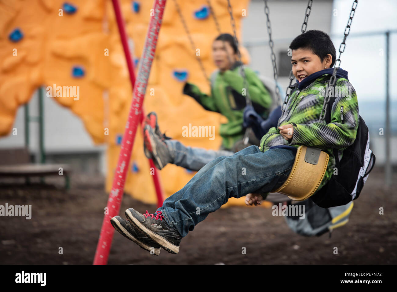 Children swing on a swingset outside of the school in Savoonga, Alaska