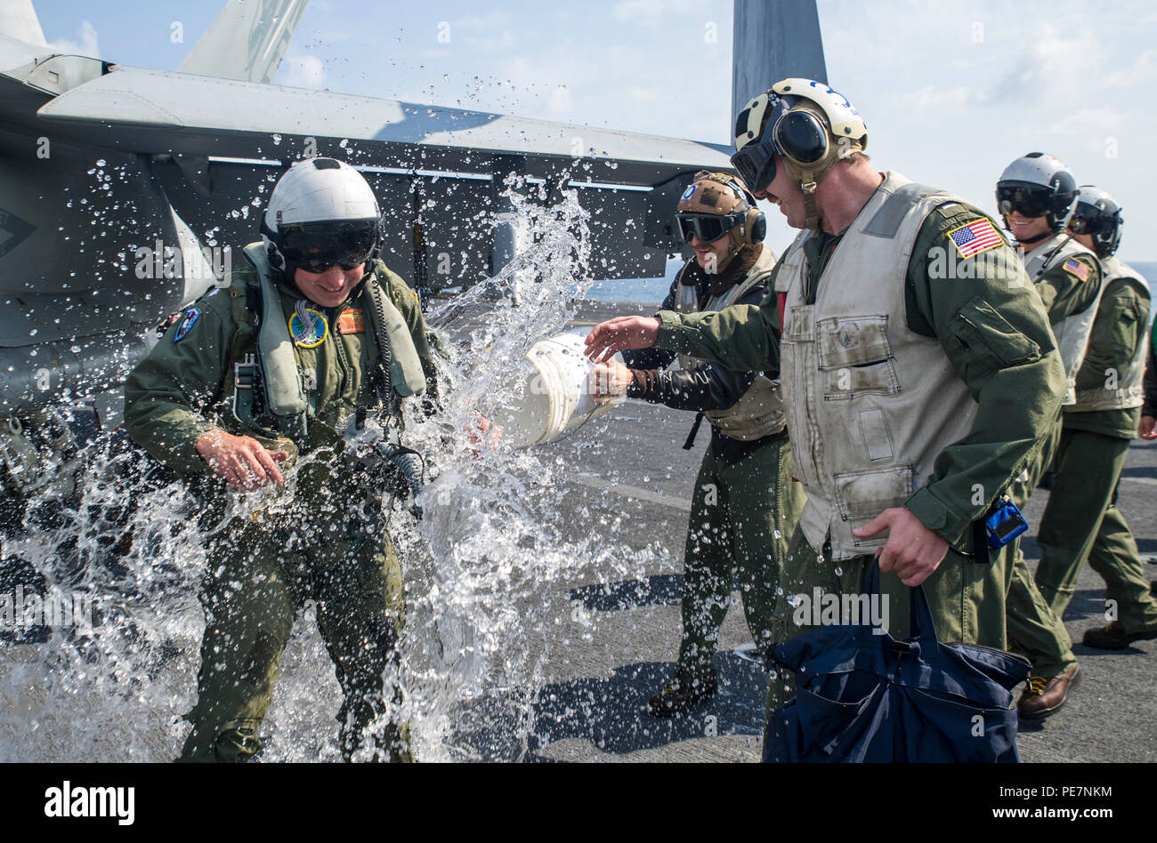 151019-N-EH855-300 PACIFIC OCEAN (Oct. 19, 2015) Sailors assigned to the 'Golden Dragons' of Strike Fighter Squadron (VFA) 192 douse Cmdr. Brett Lassen, former commanding officer of VFA-192, with water on the flight deck of aircraft carrier USS George Washington (CVN 73) after a VFA-192 change of command ceremony. UNITAS 2015, the U.S. Navy's longest running annual multinational maritime exercise, is part of the Southern Seas deployment planned by U.S. Naval Forces Southern Command/U.S. 4th Fleet. This 56th iteration of UNITAS is conducted in two phases: UNITAS PACIFIC, hosted by Chile, Oct. 1 Stock Photo