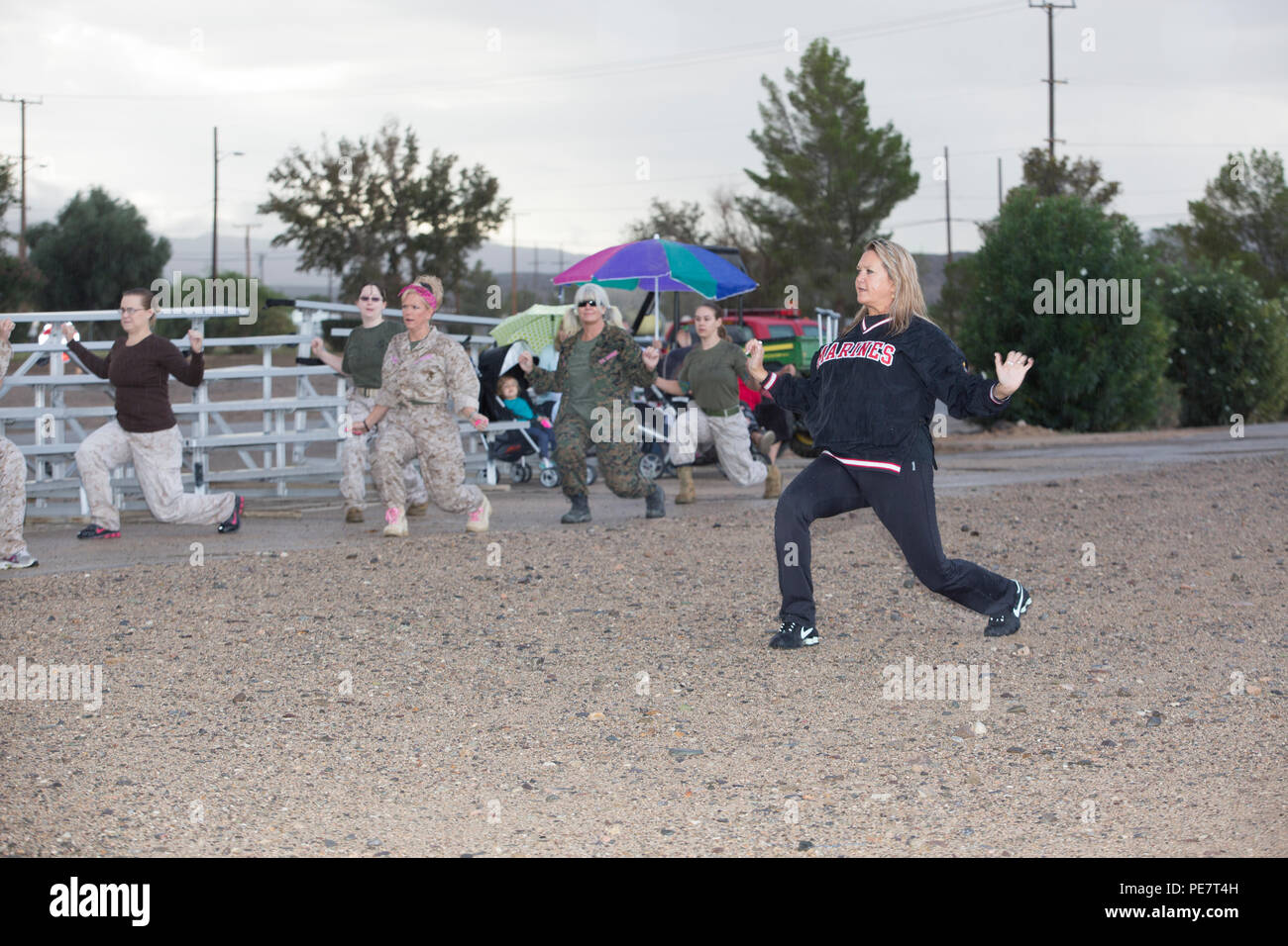 Shelley Lamey, Director of the Semper Fit aboard Marine Corps Logistics Base Barstow, leads a stretching and warm up routine before the obstacle course portion of Jane Wayne Day aboard the installation, Oct. 15.  The event included activities at the base obstacle course, rifle range, and maintenance facilities. Stock Photo