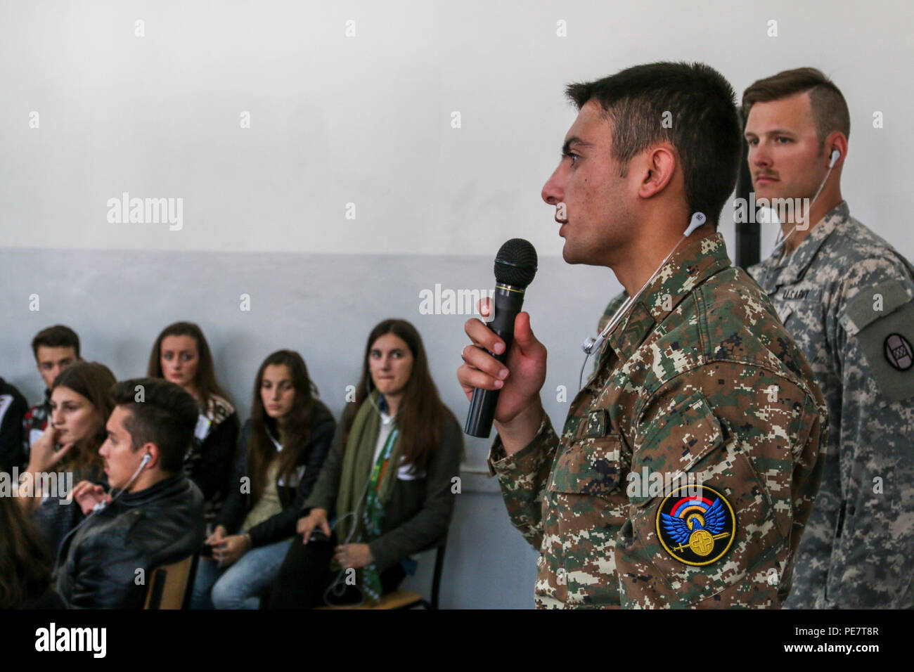 An Armenian Soldier serving in Kosovo with Multinational Battle Group-East speaks to a class of students about what makes a good leader, while volunteering at a Violence Free Future youth tolerance event Oct. 17, 2015, in Kacanik, Kosovo. Several Members of MNBG-E volunteered their free time to help with the event, where more than 100 students learned about overcoming stereotypes and solving differences without violence. (U.S. Army photo by Staff Sgt. Mary Junell, Multinational Battle Group-East) Stock Photo