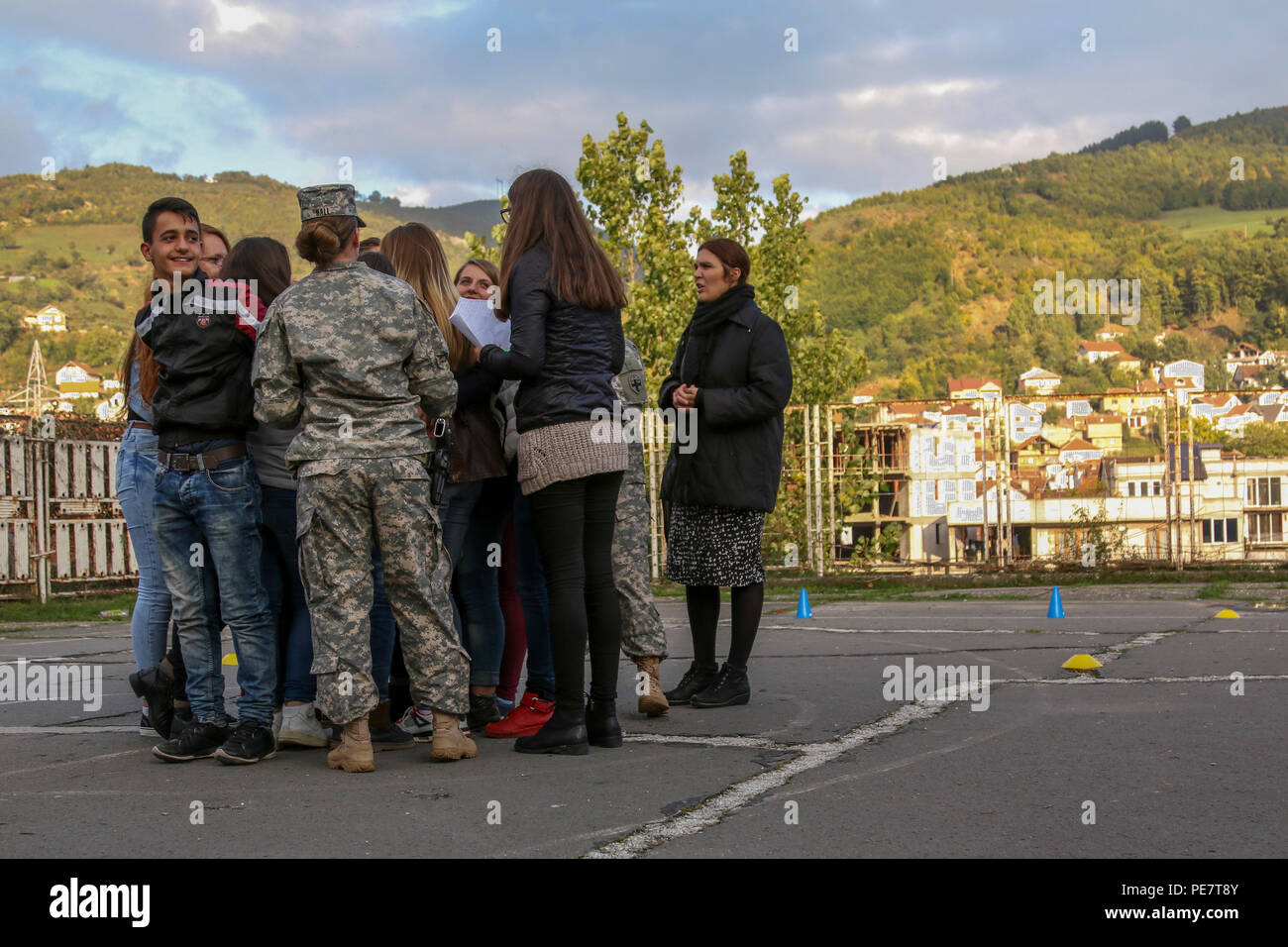 Sgt. Brittany Hall, a U.S. Army Reserve Soldier deployed to Kosovo with the 345th Combat Support Hospital, leads a group of students attending a Violence Free Future youth tolerance event through a game called The Human Knot, Oct. 17, 2015, in Kacanik, Kosovo. During the game, participants used teamwork and communication skills to untangle themselves without letting go of each other’s hands. Hall and several other members of Multinational Battle Group-East volunteered their free time to lead this and other games, used to simulate real-life situations and start conversations about promoting pro Stock Photo