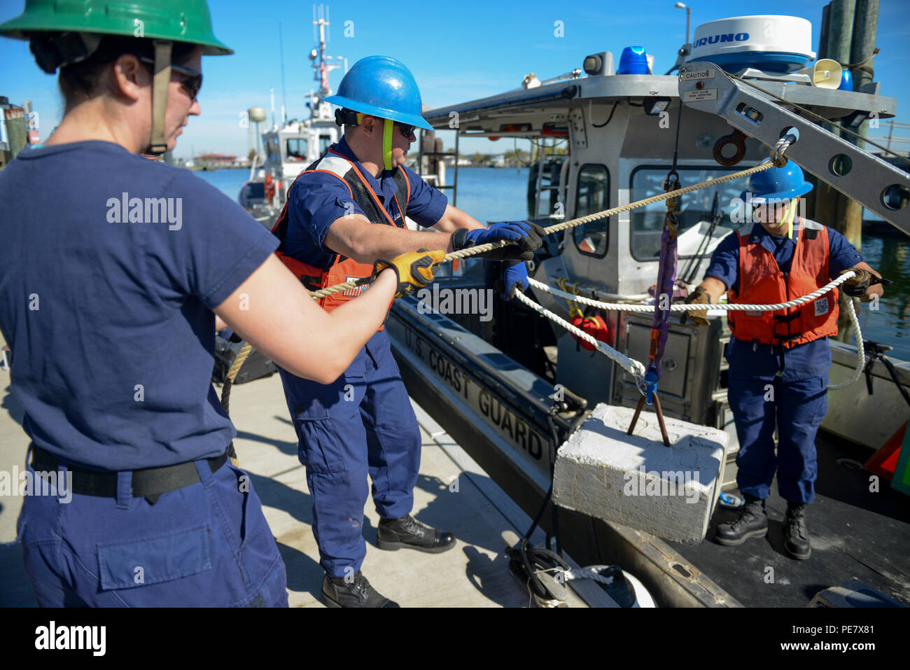 (Left to right) Fireman Brittany Barba, Petty Officer 2nd Class Justin Thornton, and Petty Officer 3rd Class Collin Blugis conduct a dynamic load test on the crane onboard the 26-Foot Trailerable Aids to Navigation Boat from Coast Guard Aids to Navigation Team, Crisfield, Md., Wednesday, Oct. 21, 2015. Crew members from ANT Crisfield were performing davit inspections, as well as static and dynamic load tests for the crane aboard the TANB. (U.S. Coast Guard photo by Petty Officer 2nd Class David Marin) Stock Photo