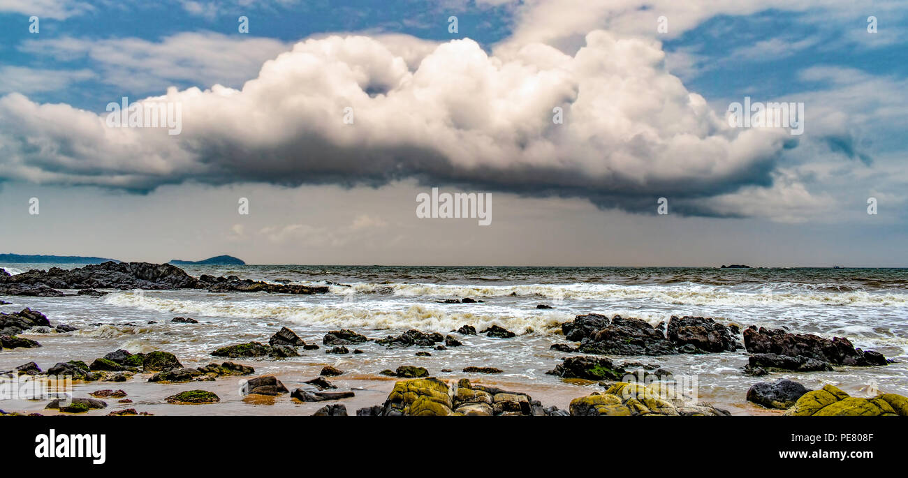 Beautiful panoramic view of landscape or seascape with dramatic cumulus clouds, stormy and blackish, in blue sky about to rain in rainy monsoon season Stock Photo