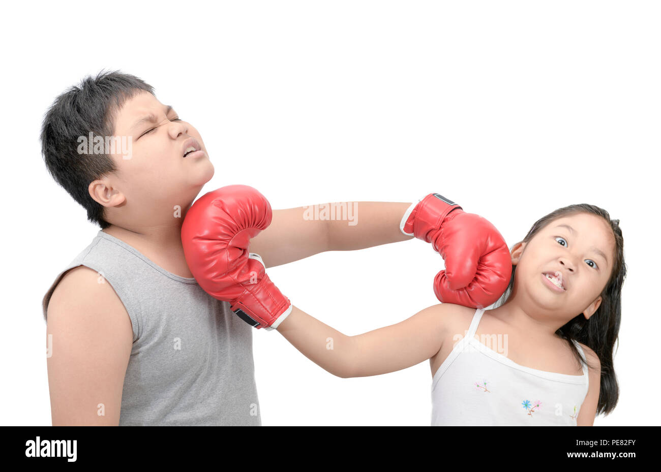 Brother and sister fighting with red boxing gloves isolated on white background. Stock Photo
