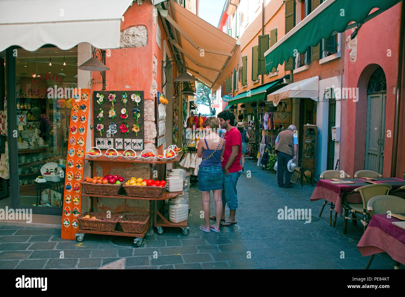 Touristen an einem Souvenirladen in der Altstadt von Garda, Gardasee, Lombardei, Italien | Tourist at a souvenir shop, old town of Garda, province Ver Stock Photo