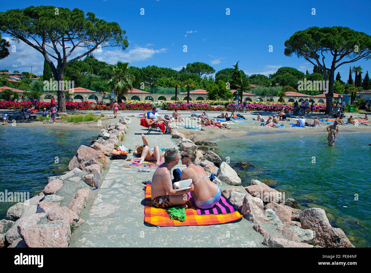 Menschen am Strand von Lazise, Gardasee, Provinz Verona, Italien | People at beach of Lazise, Garda lake, province Verona, Italy Stock Photo