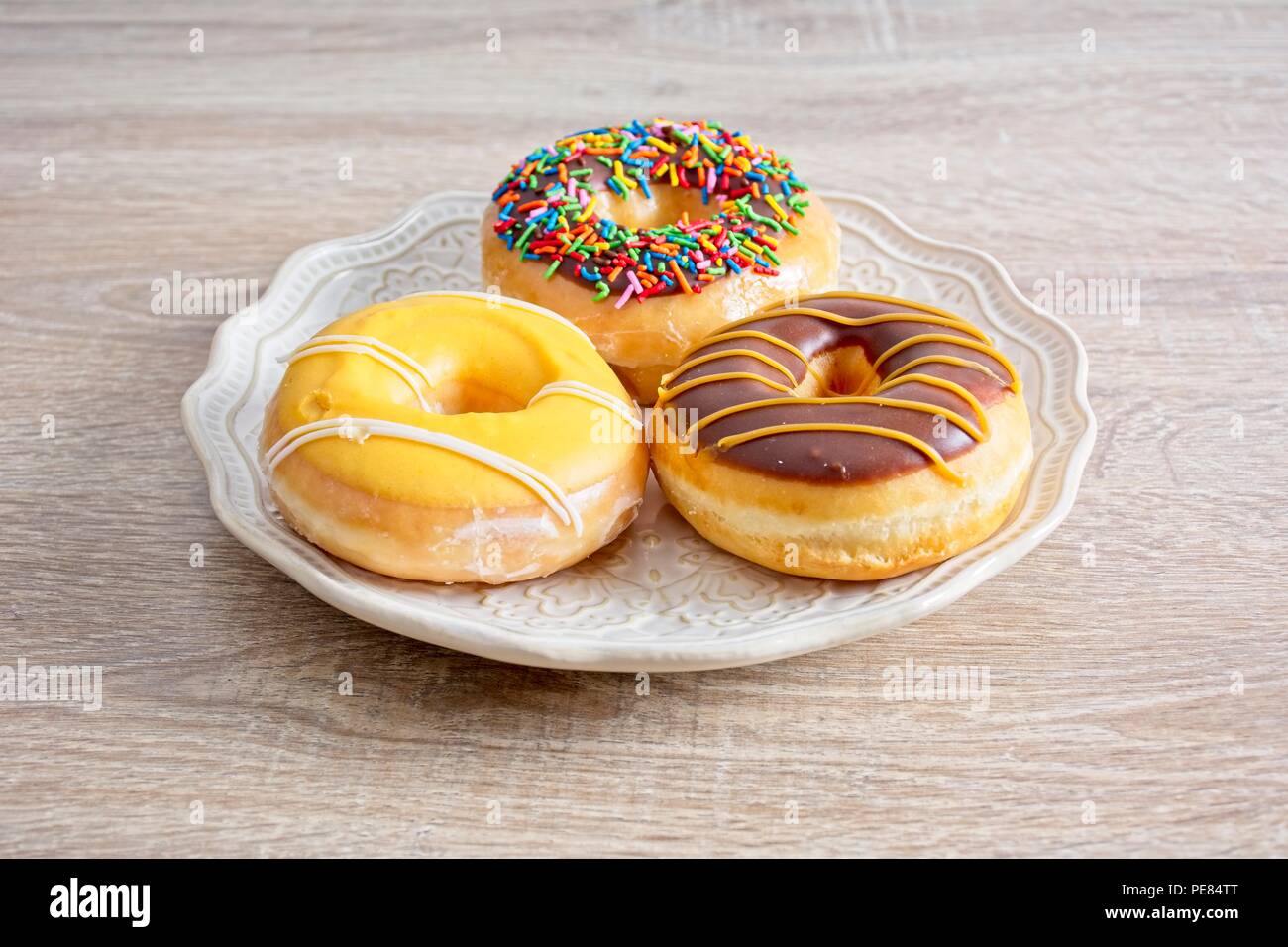 Three doughnuts, white plate, side view, Stock Photo