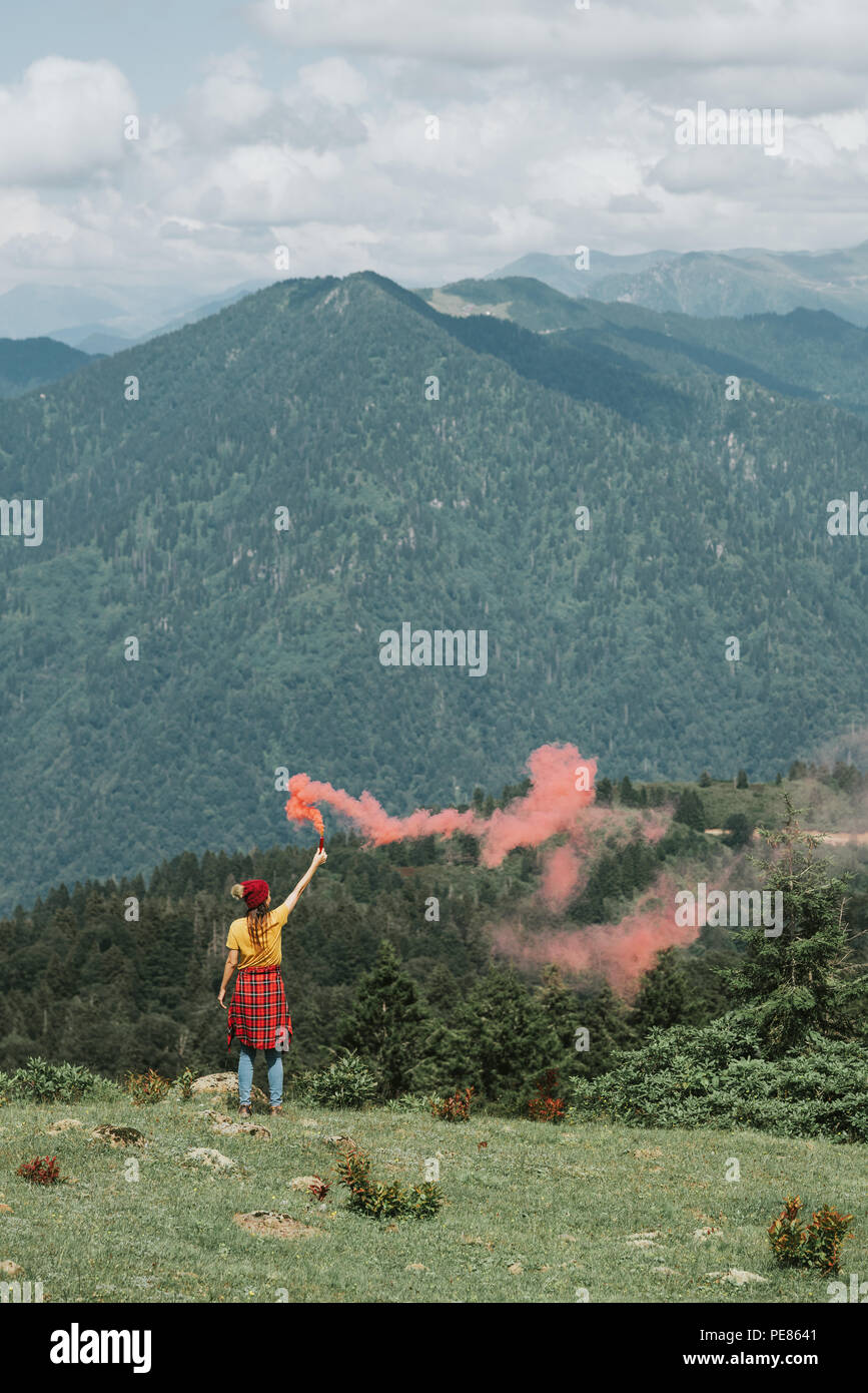 Woman on mountain peak with red flare.Inspiration concept Stock Photo