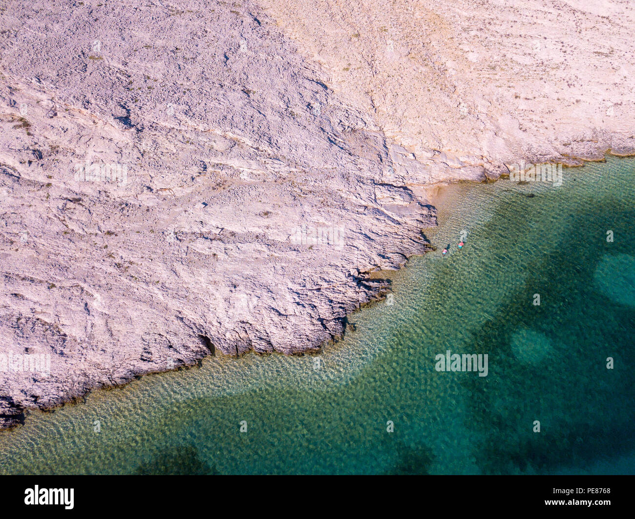 Aerial view of people moving among the rocks in the sea. Overview of ...