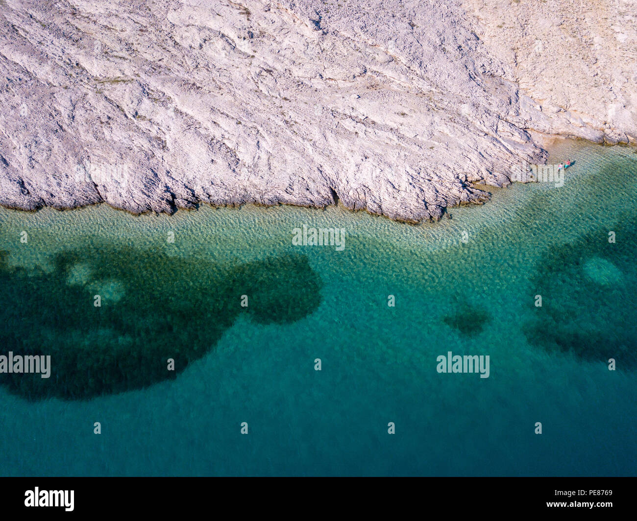 Aerial view of people moving among the rocks in the sea. Overview of ...