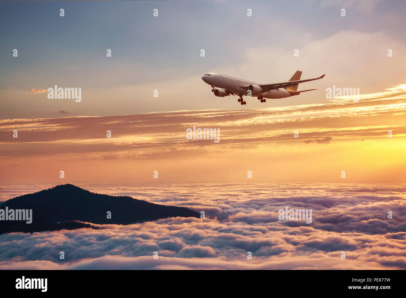 Airplane in the sky at sunset - Passenger Airliner aircraft. Stock Photo