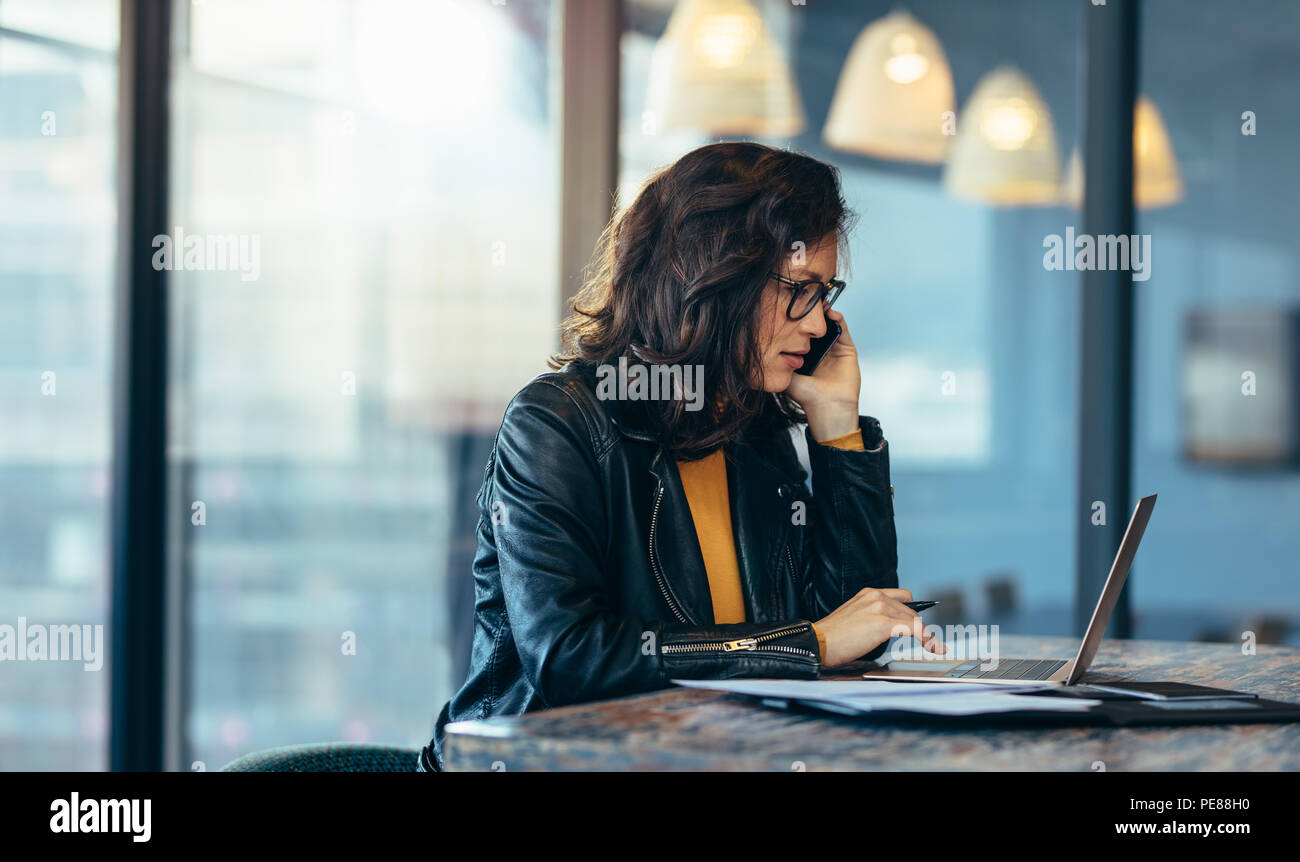 Business Woman Sitting Working At Office And Talking On Mobile Phone
