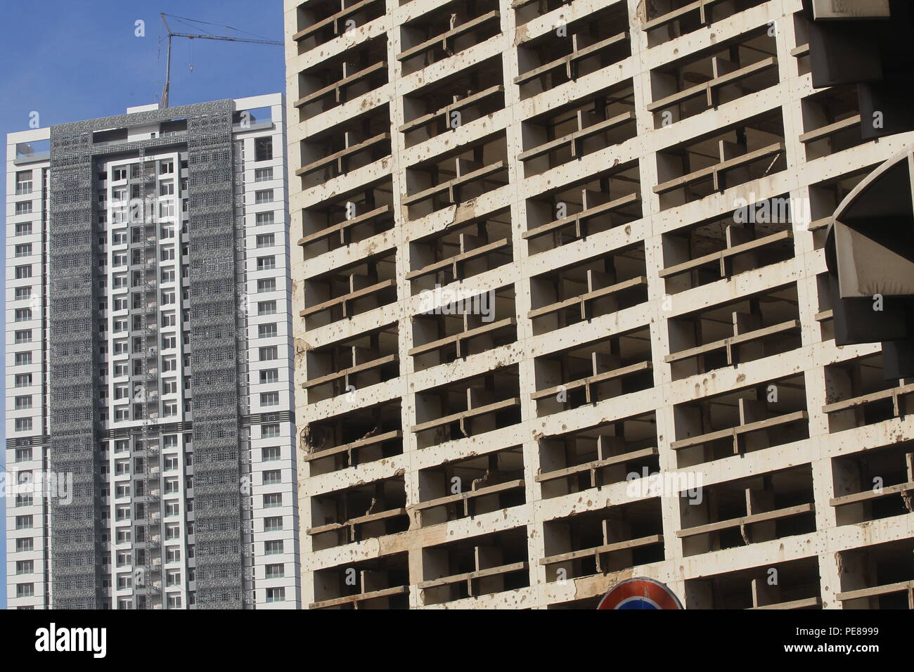 Shell-pocked Holiday Inn hotel is seen near plush buildings at what used to be one of Beirut’s killing fields during Lebanon’s 1975-1990 civil war. Stock Photo