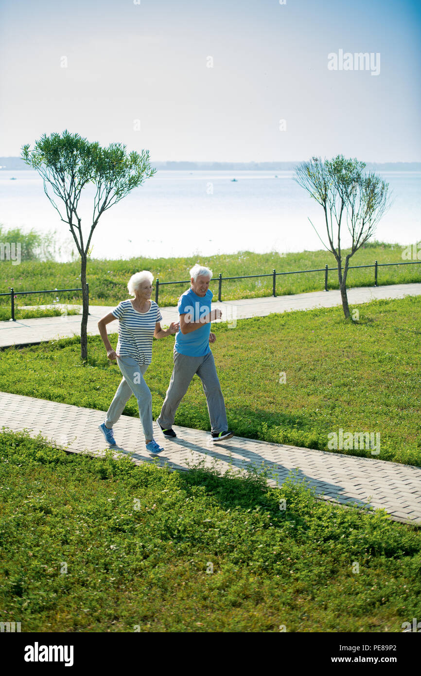 Senior Couple Running in Park Stock Photo